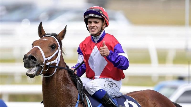 A jockey smiles on a horse