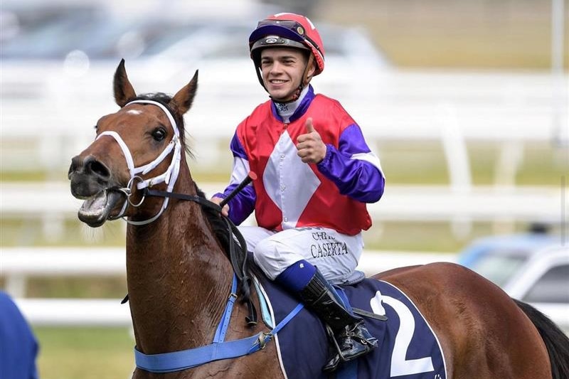 A jockey smiles on a horse