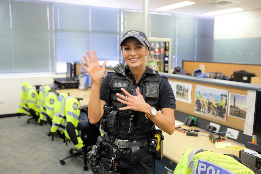 Qld police Constable Latisha Whalan in uniform in police office doing sign language
