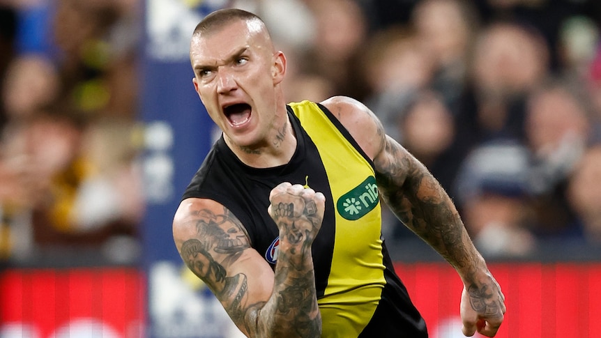 Dustin Martin pumps his fist and yells in delight