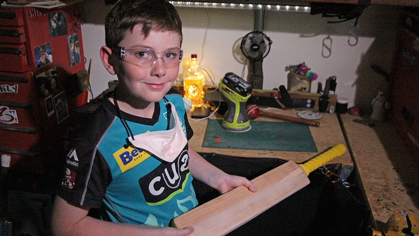 Riley Parsons shows off one of the bats he's refurbished to go to kids who need gear