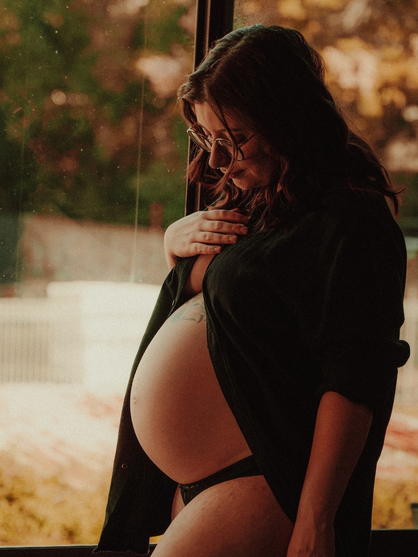 a pregnant woman standing side on showing her belly