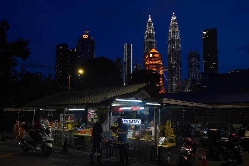 A local food vendor prepares food in downtown Kuala Lumpur