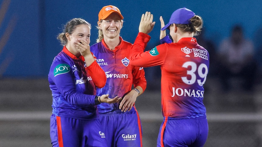 Alice Capsey, Meg Lanning and Jess Jonassen celebrate a wicket for the Delhi Capitals in the Women's Premier League.