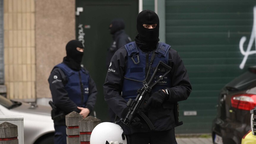 Police officers stand guard in Molenbeek district, Brussels
