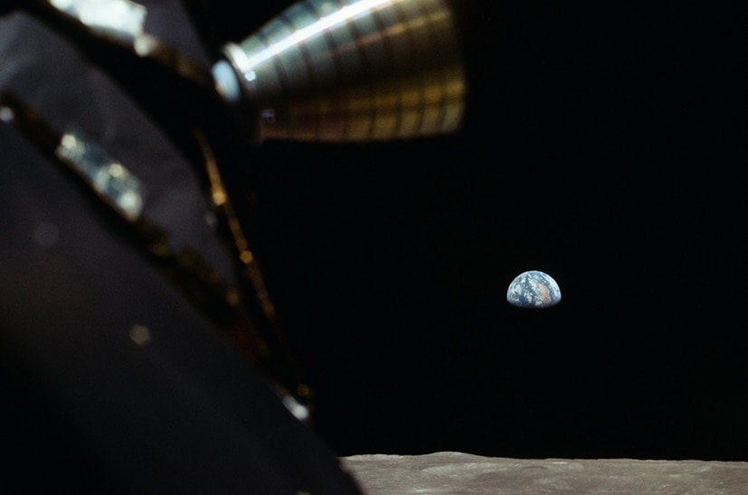 Planet Earth as seen from the surface of the moon and surrounded by a vast empty black space.