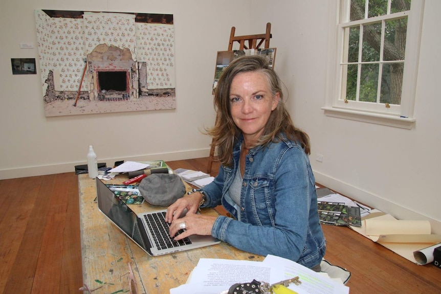 A woman uses her laptop at a table