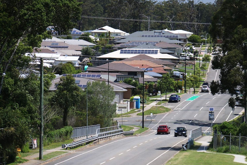 Traffic driving along street at a new housing estate.