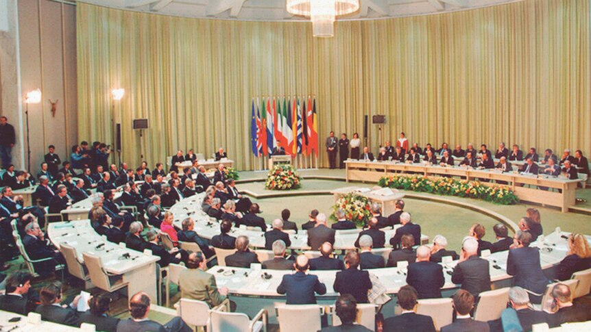 The signing of the treaty which began the EU. A crowd of officials are seated in a semi-circle