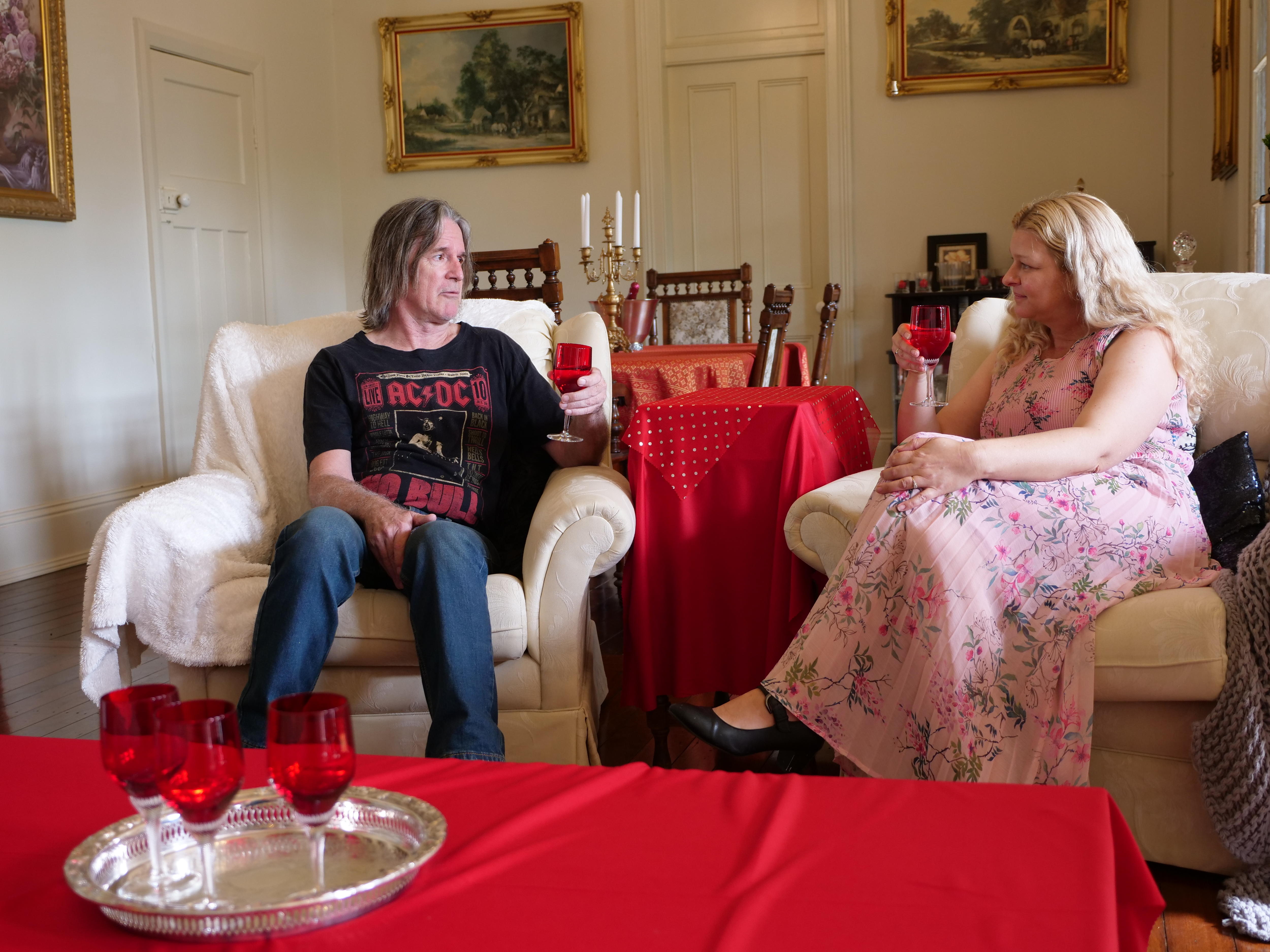 A man and a woman sit on a couch.