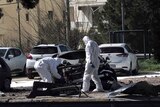 Greek forensic experts search the damaged Mercedes-Benz.