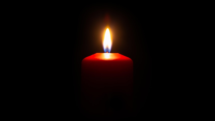 A lit candle in the dark. 