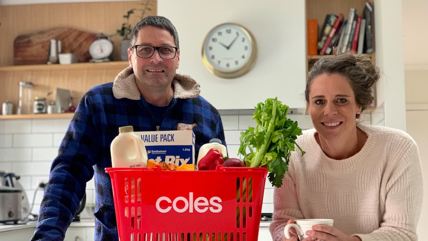 Two people standing near a coles basket