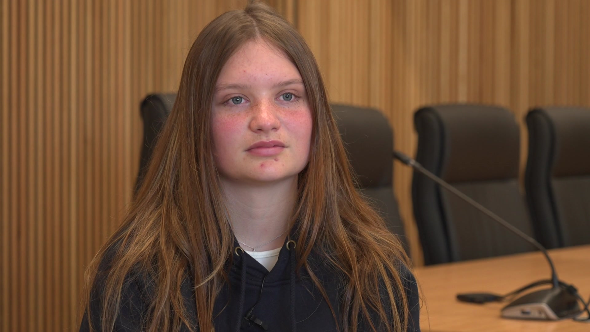 A teenage girl sitting down as part of a television interview.