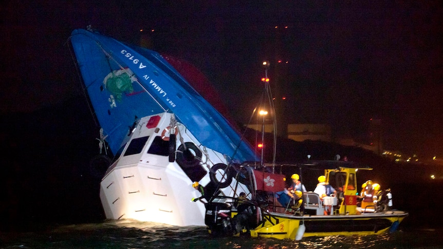 Rescuers approach a partially submerged boat after two vessels collided off Hong Kong.
