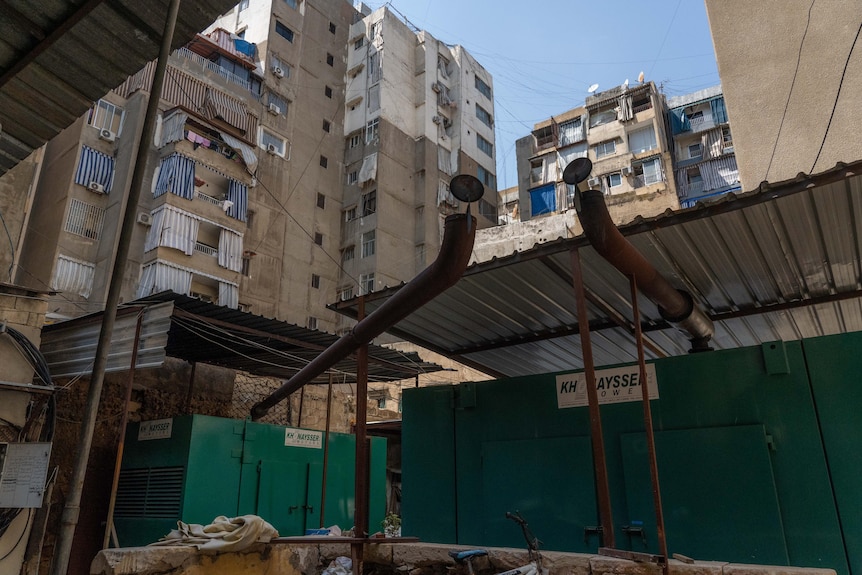 Two big green generators at the bottom of apartment buildings in Beirut 