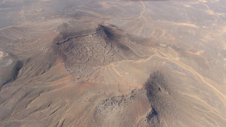An aerial view of a hilltop site with stone fortresses