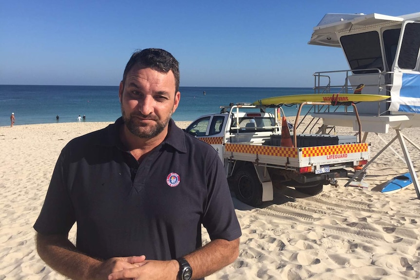 General manager Surf Life Saving WA Chris Peck standing at the beach with the ocean in the background.