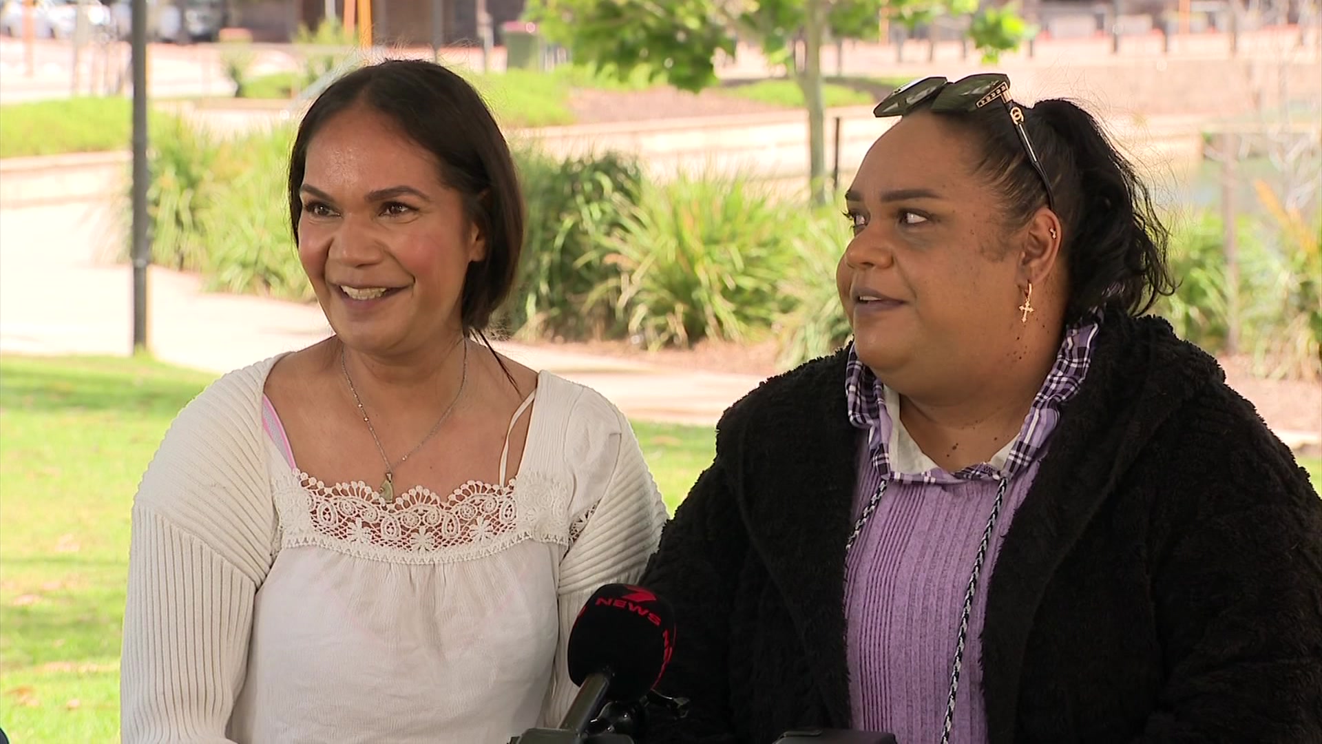 Two women smile at the camera as they speak to a reporter