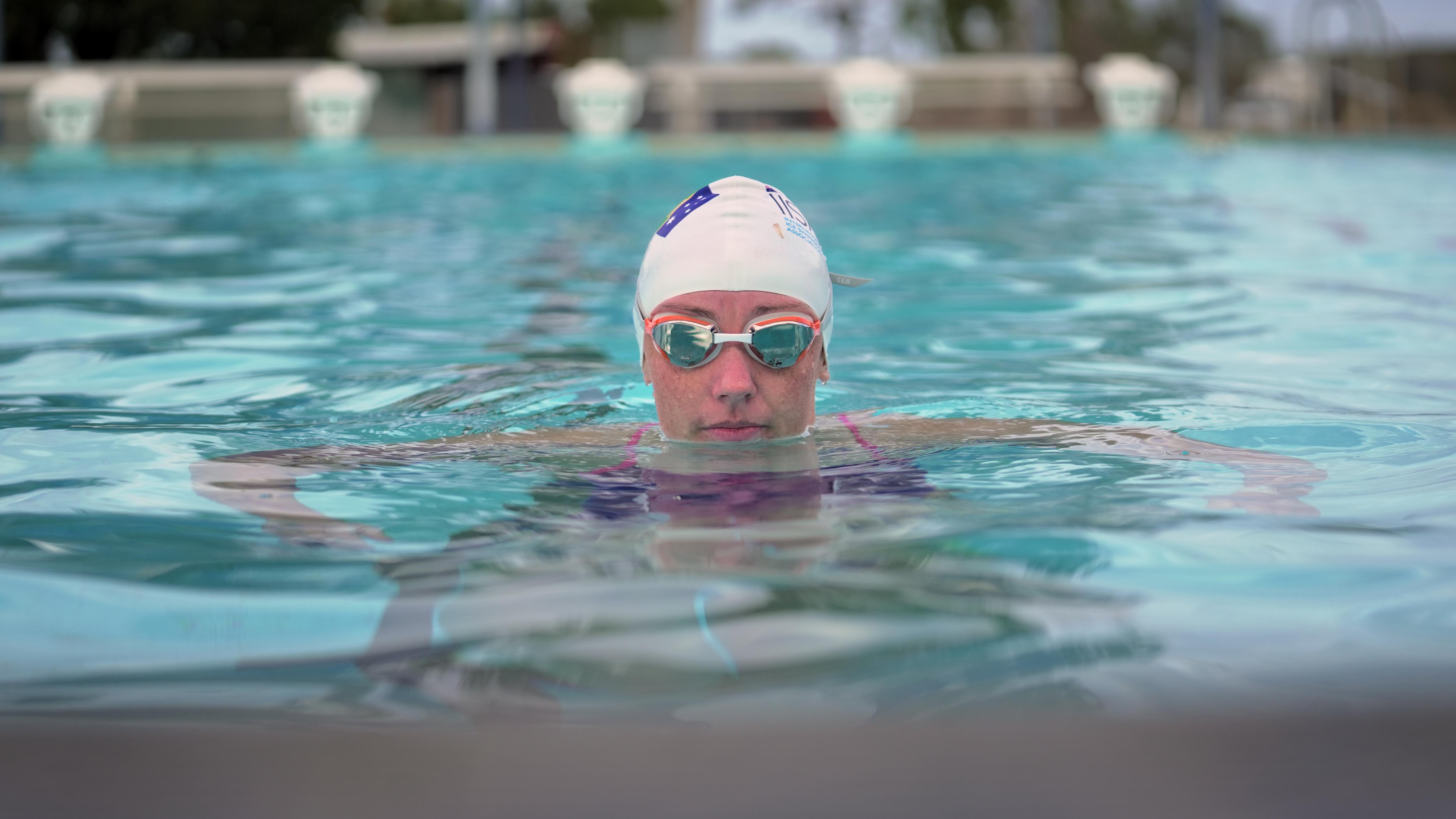 A woman with goggles on in the water.