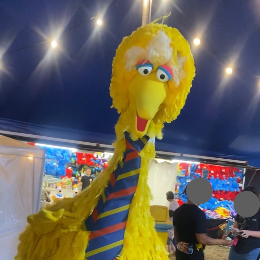 A large yellow bird costume wearing a tie