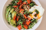 Chopped roasted carrots in a salad with quinoa, avocado, fried egg and green herby sauce.