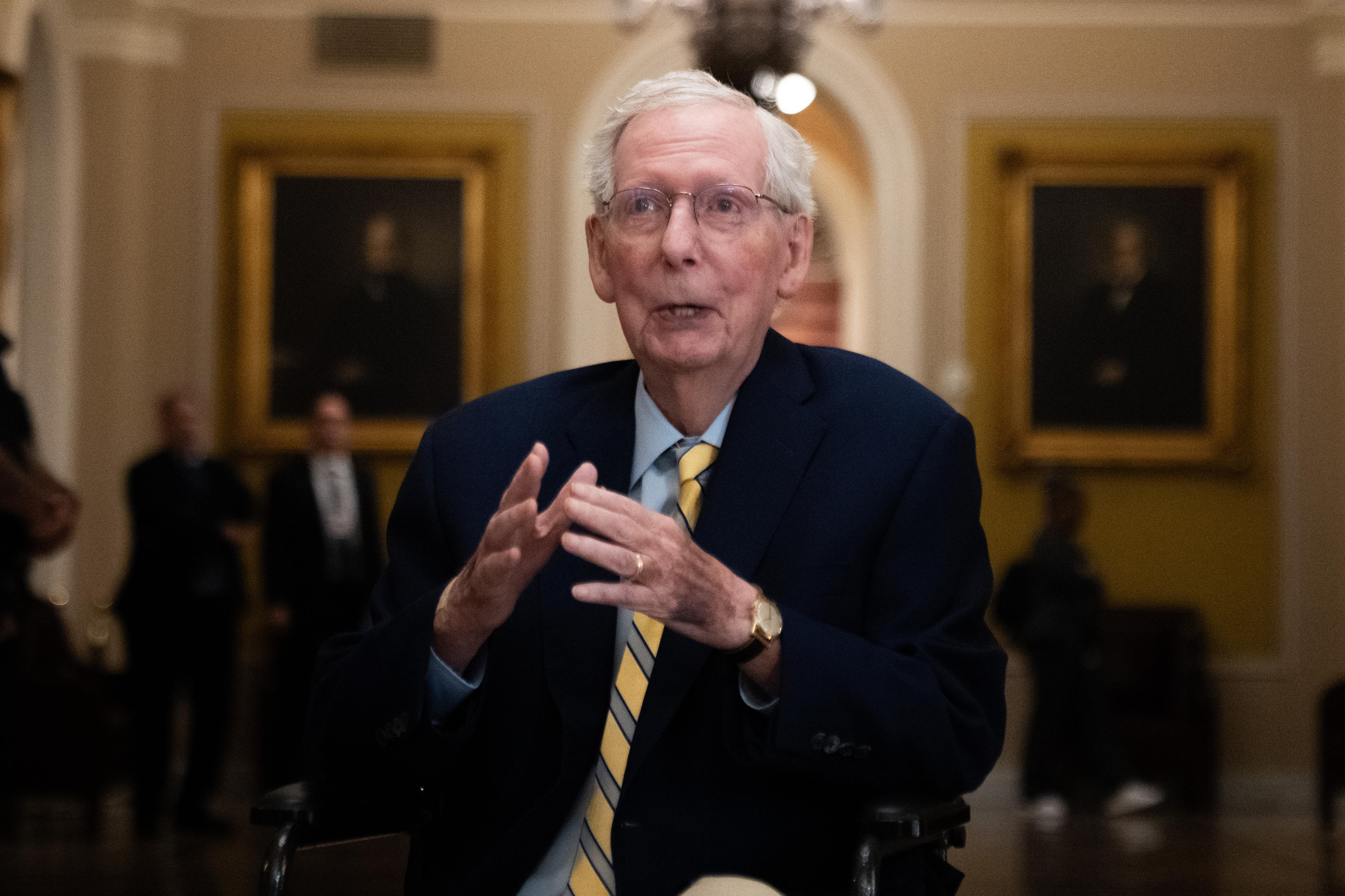 an older man talks to media inside the US Capitol foyer