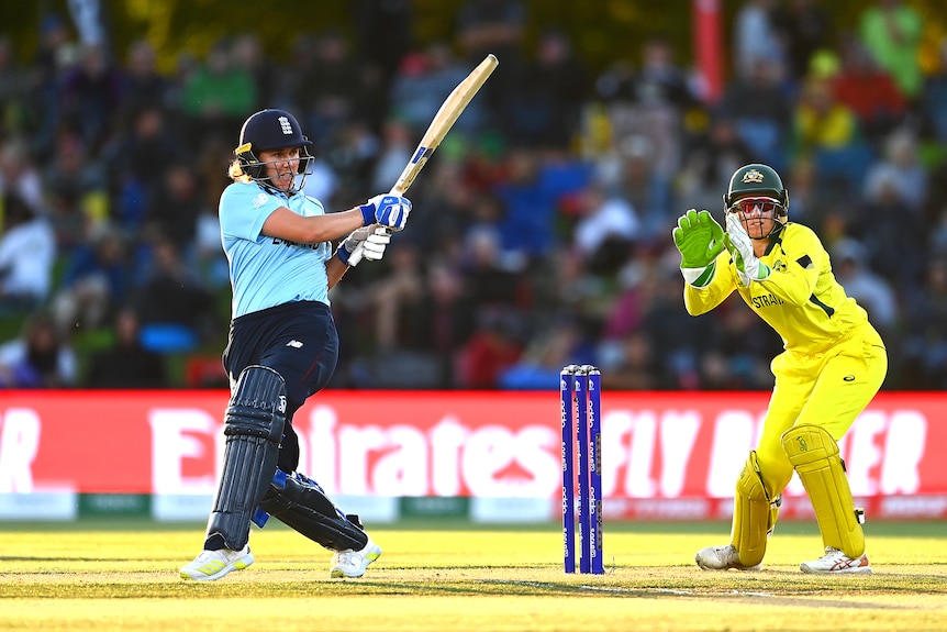 England batter Nat Sciver completes a pull shot as Australia wicketkeeper Alyssa Healy shapes to catch the ball.