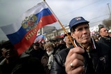 Man hold Russian flag at rally in Simferopol