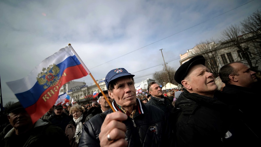 Man hold Russian flag at rally in Simferopol