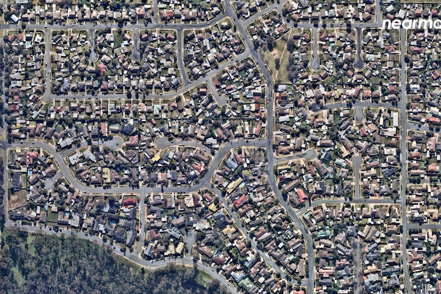 This picture shows homes built closely together with parkland around the edge of the suburb