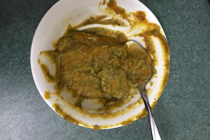 Brown and green puree in a bowl.