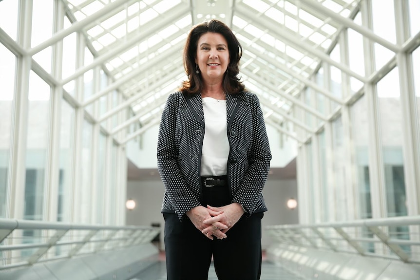 Jane Hume stands in a glass atrium