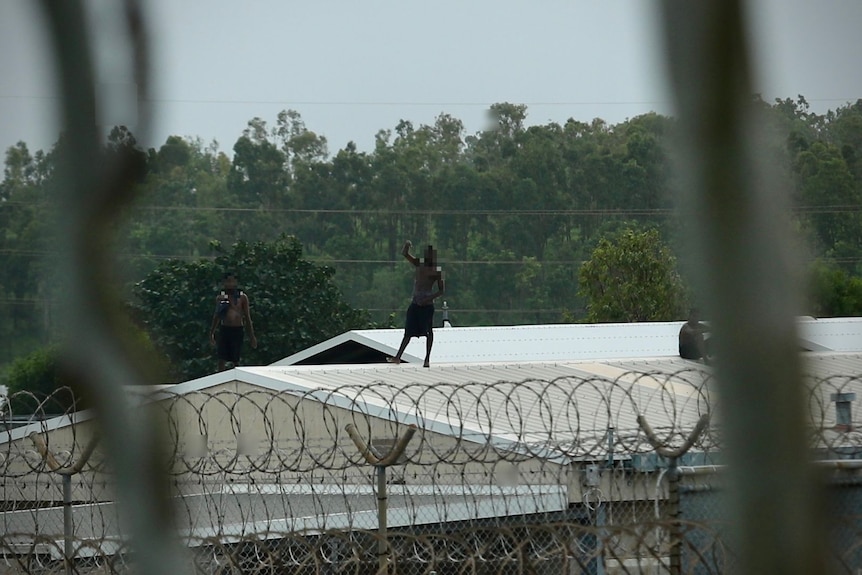 Youth detainees on roof of prison behind barbed wire