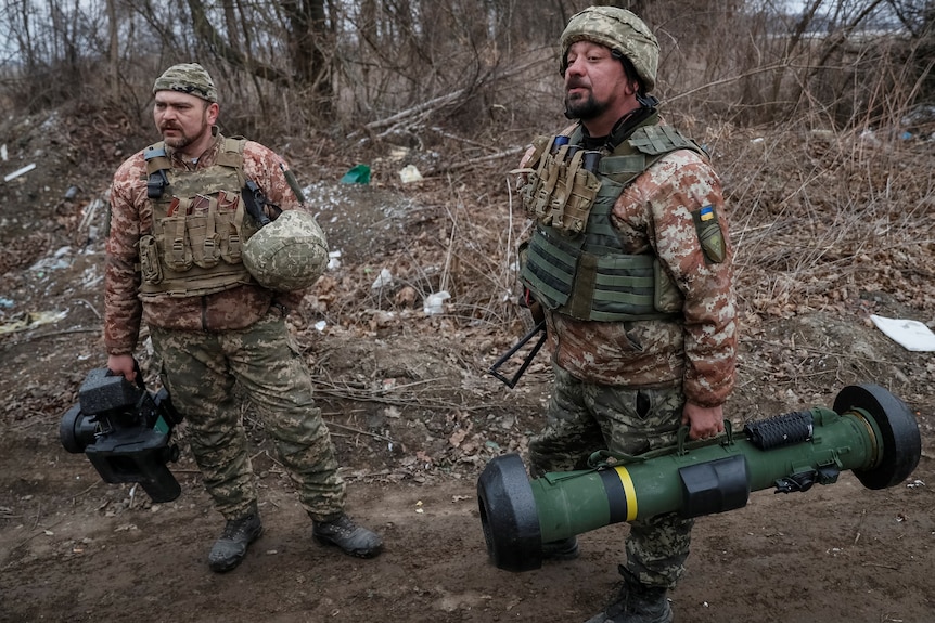 Ukrainian service members hold a Javelin missile system.