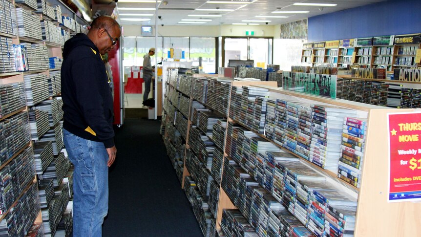 Customer looks at DVDs in DVD store.