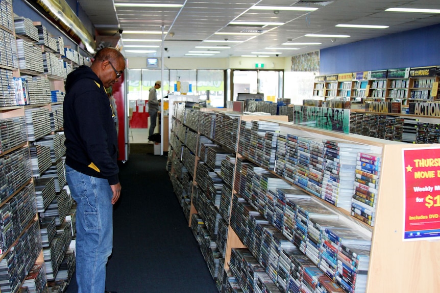 Customer looks at DVDs in DVD store.