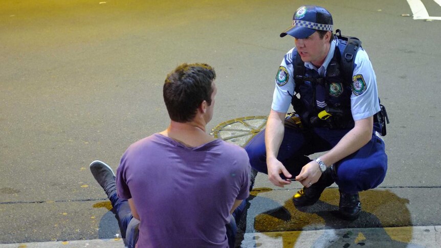 Police speak to a man in Kings Cross