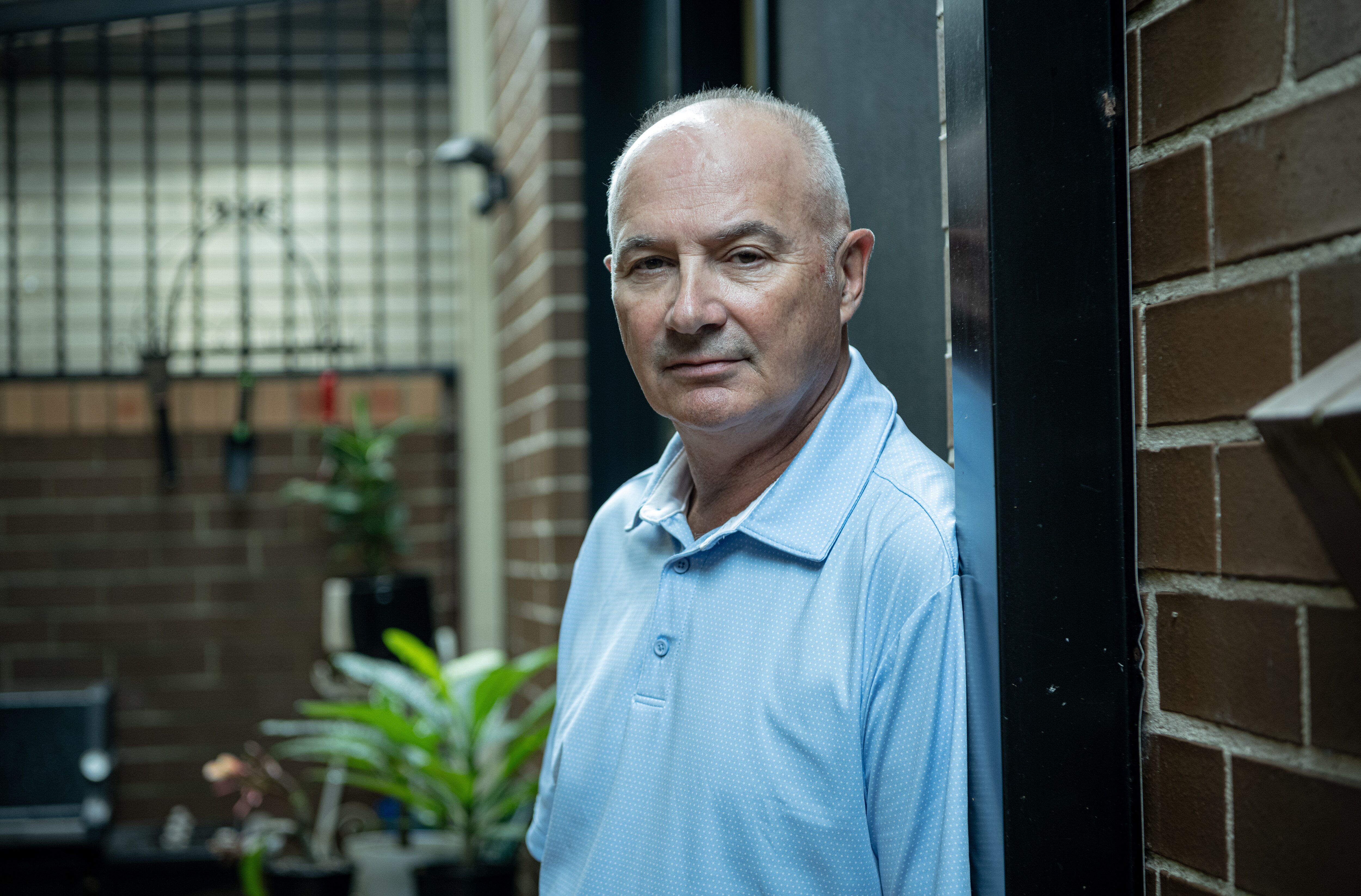 Tim Stannard leans on a brick wall