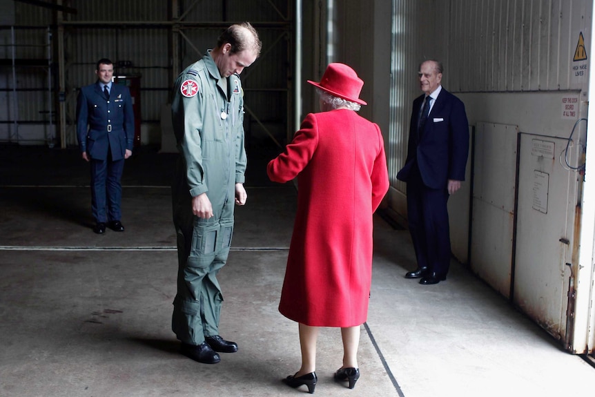 Queen Elizabeth talks with her grandson Prince William at an Army base.