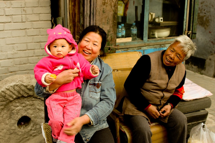 Three generations of women sitting and smiling