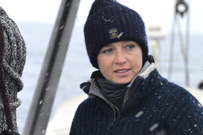 Woman standing on deck of yacht.