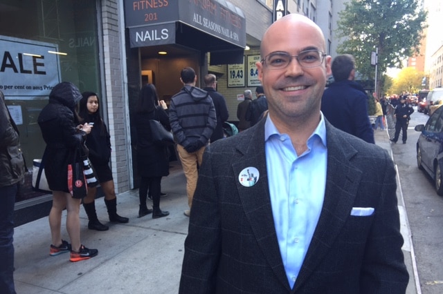 A man wearing an "I voted" badge.