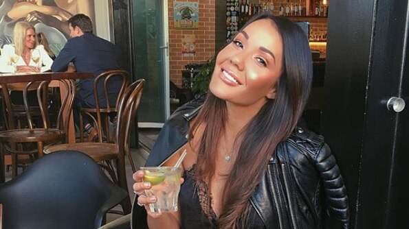 Davina Rankin sitting at a cafe with a drink in hand