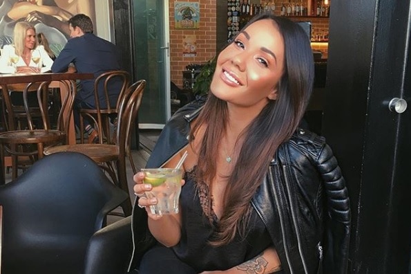 Davina Rankin sitting at a cafe with a drink in hand