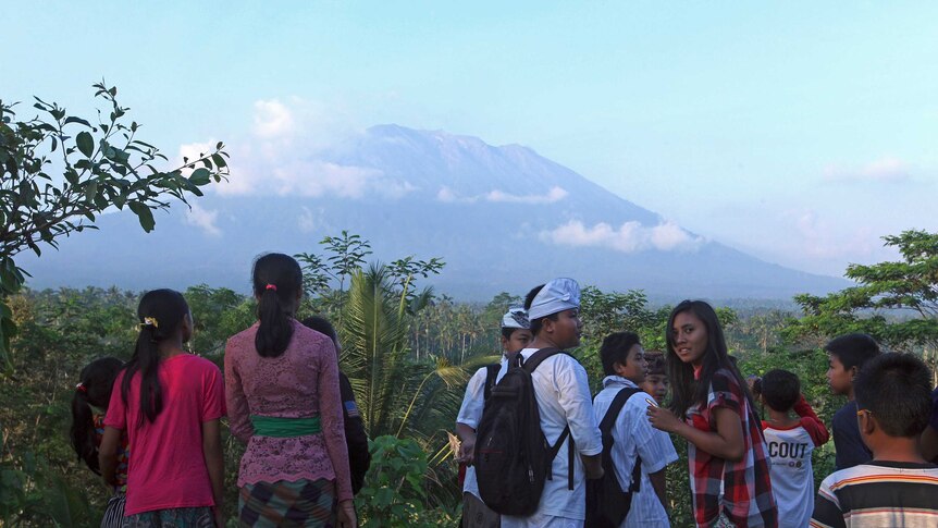 Residents observe Mount Agung from a viewing point