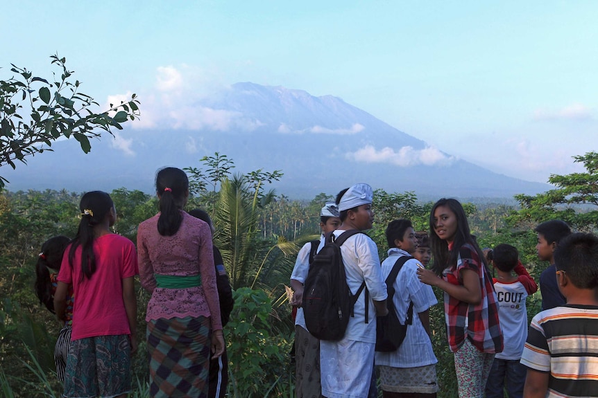 Residents observe Mount Agung from a viewing point