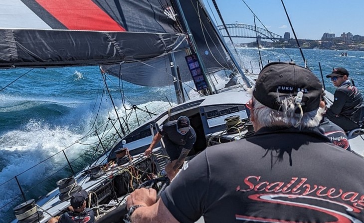 Yacht racing with Sydney Harbour Bridge in background.