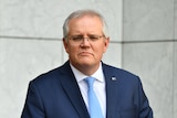 Prime Minister Scott Morrison wearing a navy blue suit speaking at a press conference