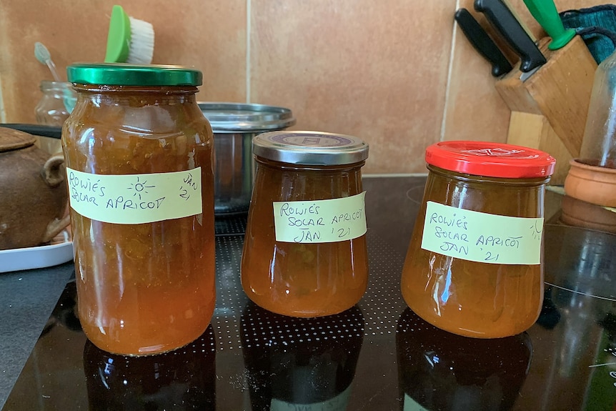 Three jars of jam on a table.